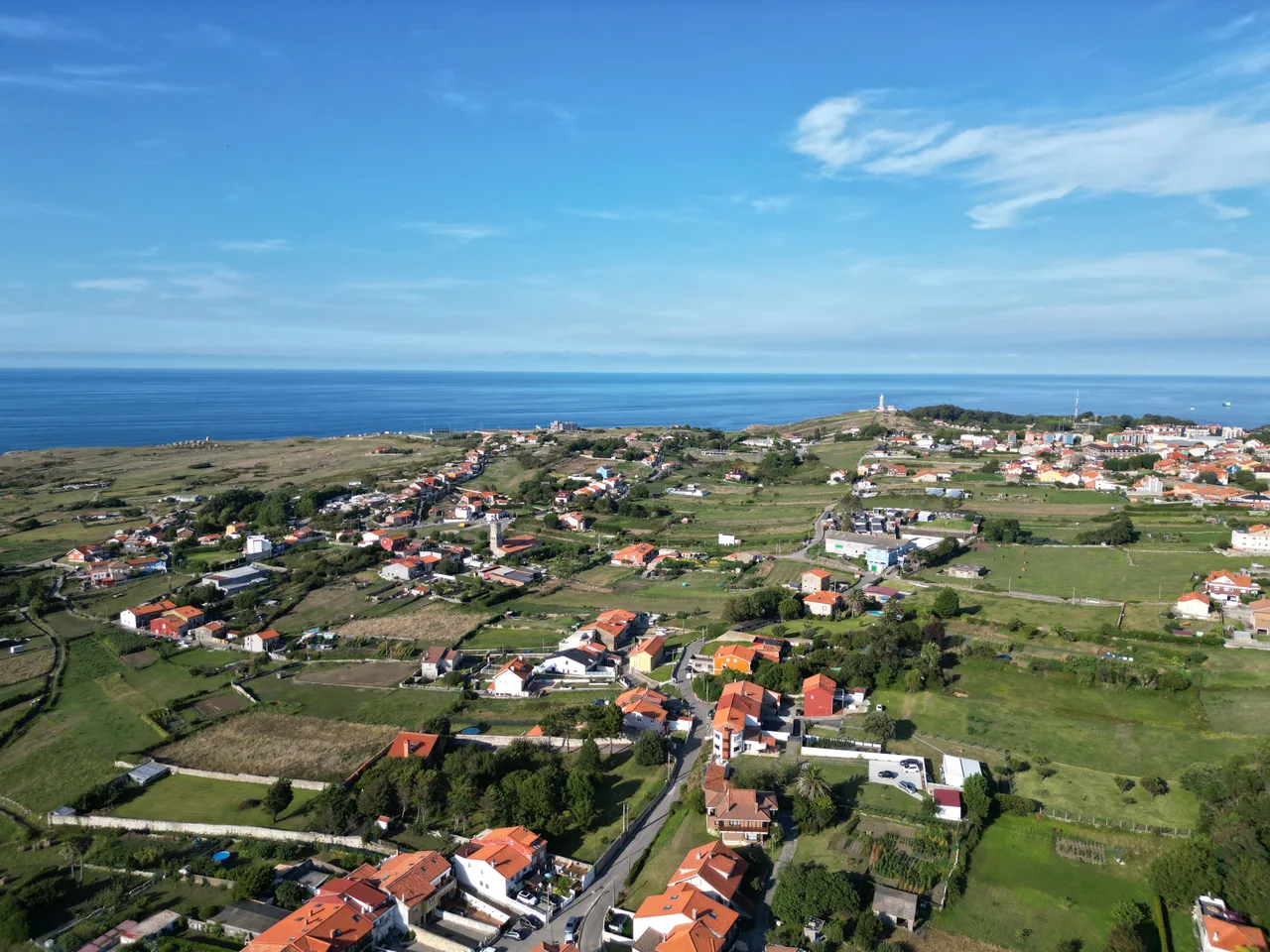 Vista aérea de Cueto en 2023 con el faro de Cabo Mayor al fondo