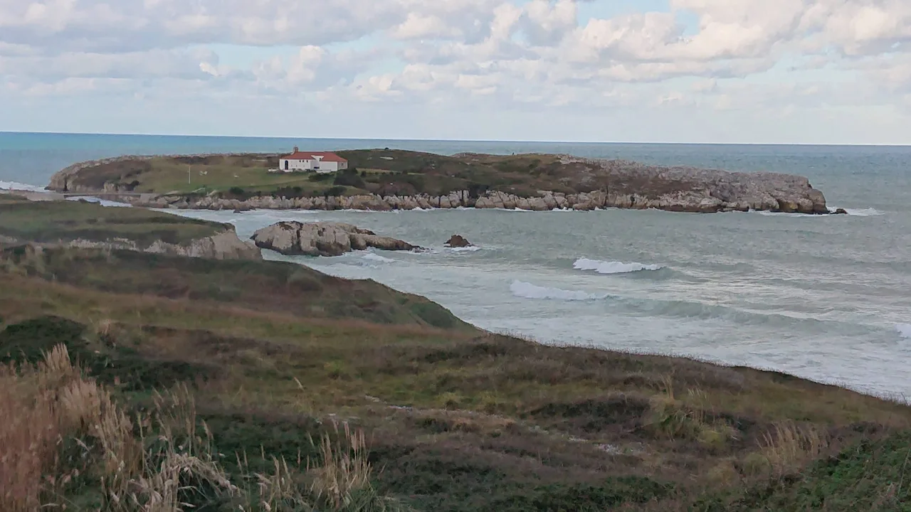 Isla de la Virgen del Mar y costa baja de San Román vistas al otro lado de la ensenada