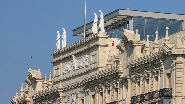 Esculturas y friso de la fachada del Banco Santander ante el volumen acristalado de la cubierta