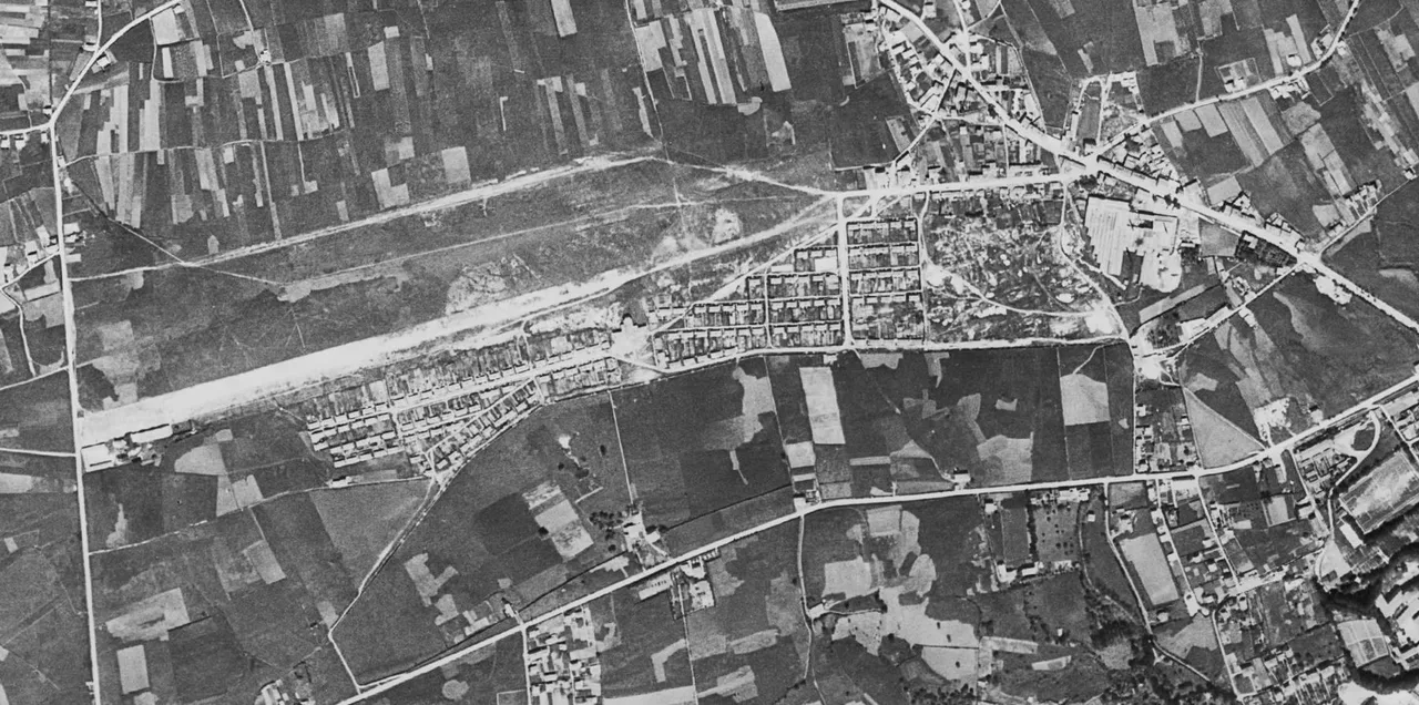 Ortofoto histórica de La Albericia con el terreno alargado del aeródromo, una franja clara junto a las viviendas y parcelas agrícolas en su entorno