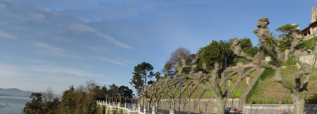 La avenida Reina Victoria junto a la bahía, con arbolado y una villa elevada sobre el paseo