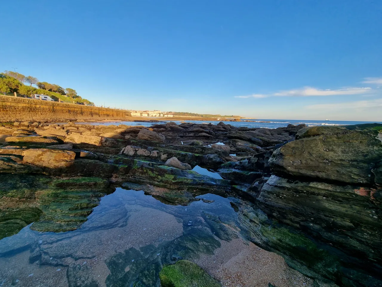 Capas de roca y charcos entre las lastras de El Camello, con la costa al fondo
