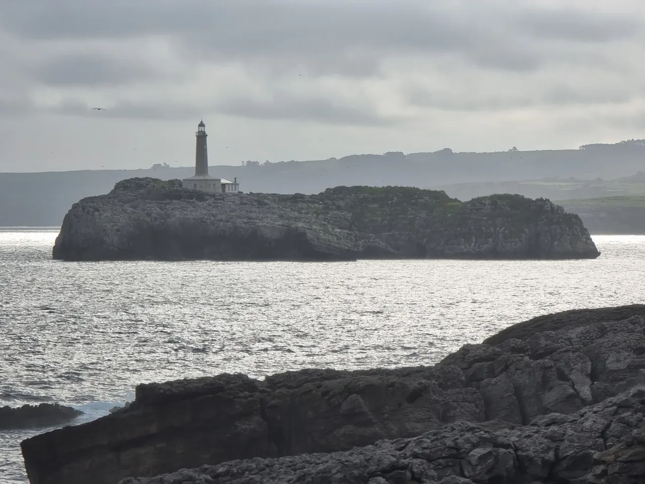 Isla de Mouro y su faro recortados contra el horizonte
