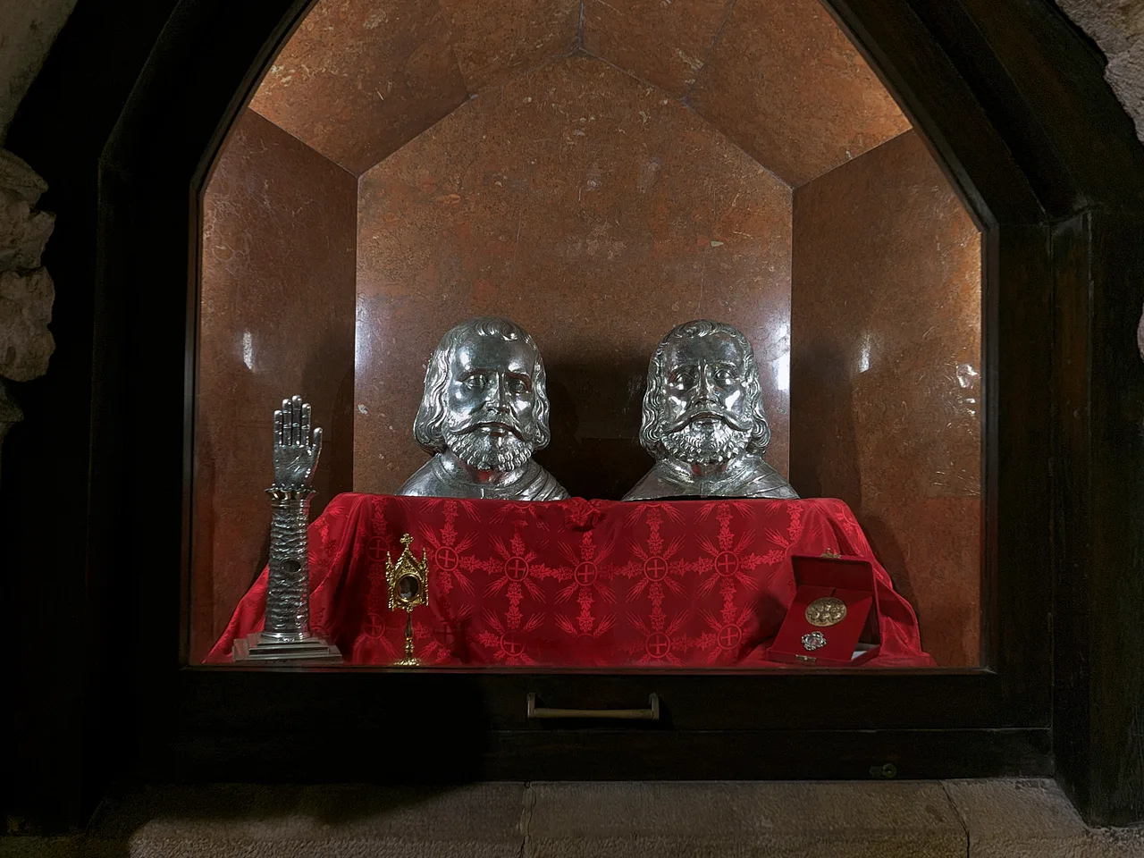 Dos bustos relicario de plata colocados tras una tela roja en la iglesia del Santísimo Cristo