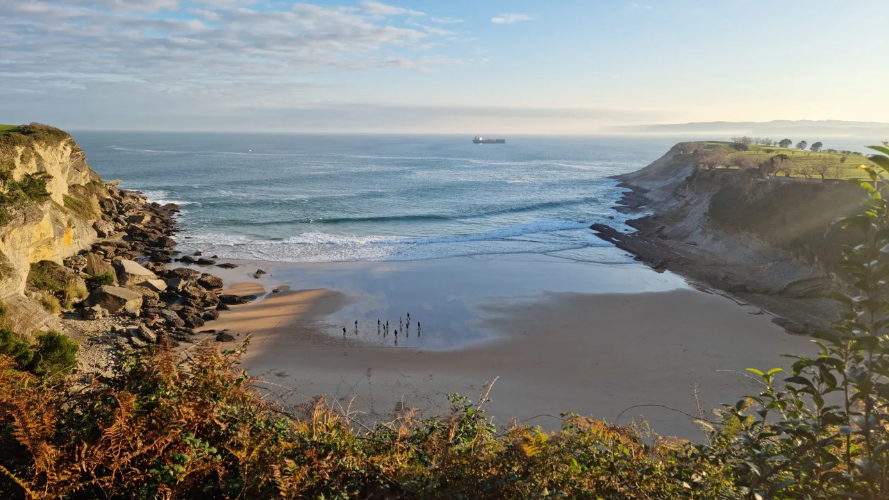 La playa de Mataleñas entre acantilados, con Cabo Menor a la derecha y el Cantábrico al fondo